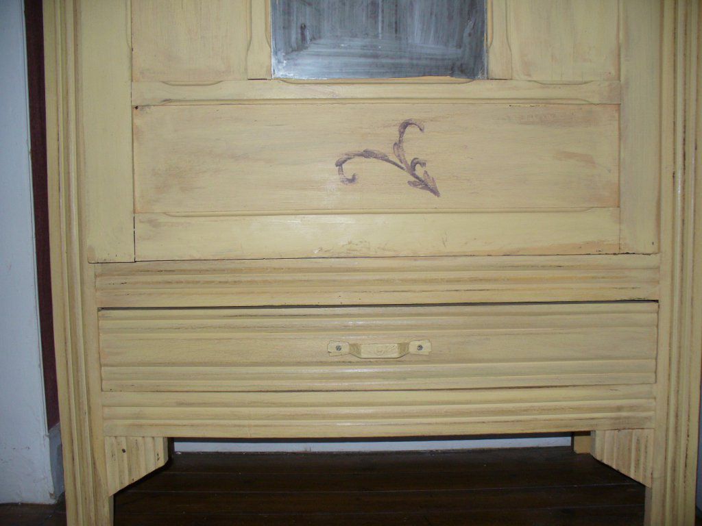 Détail du  bas de l'armoire souligné d'un motif peint en acrylique.