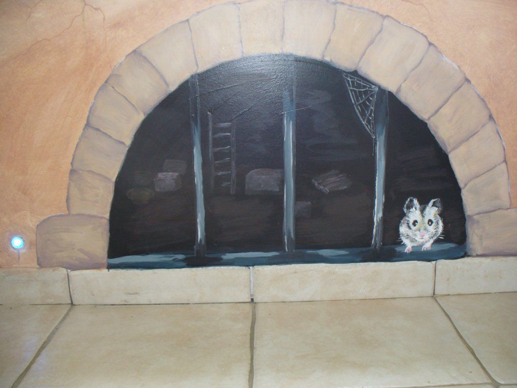 Dans un couloir sous une fenêtre, un soupirail laisse passer une petite souris, j'ai réalisé le trompe l'oeil  à l'acrylique