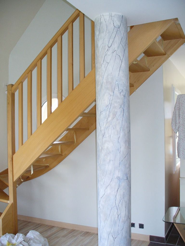 Dans la pièce de vie, un escalier en chêne clair devait se fondre avec la couleur pastel des murs